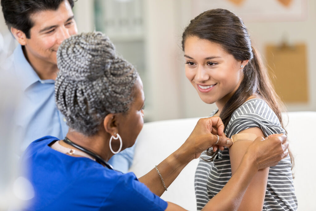 Nurse places bandage on female patient