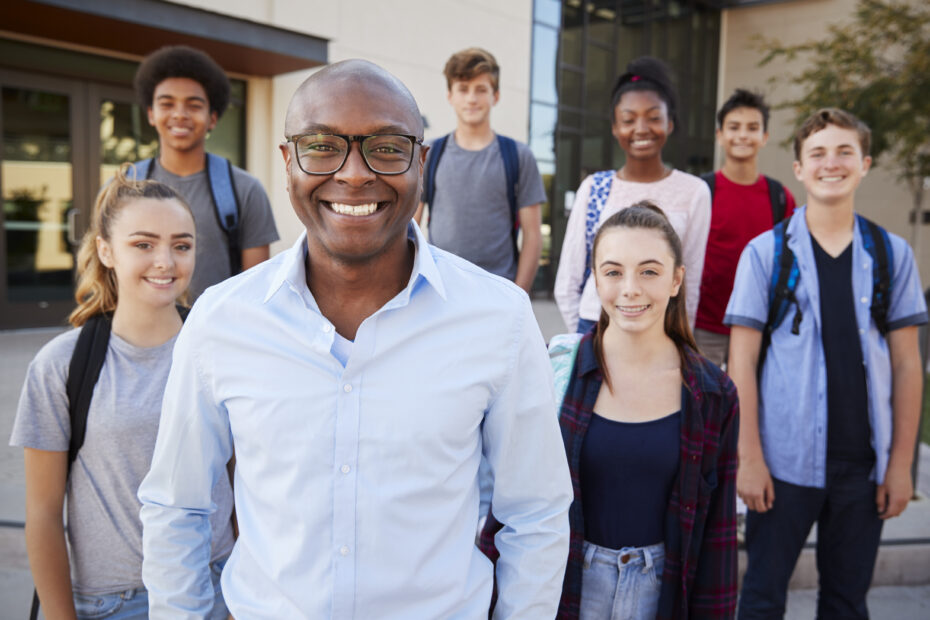 Portrait Of High School Students With Teacher Outside College Buildings